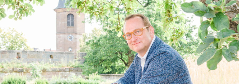 Comedian Volker Heißmann vor der Kirche in Wilhermsdorf.