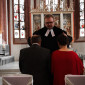 Pfarrer spricht seinen Segnen aus für das Ehejubiläum eines Paares.