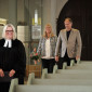 Ein Paar zieht zusammen mit der Pfarrerin in der Kirche ein.